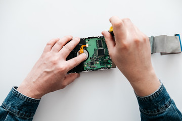 Hard disk recovery service, hands of repairman holding broken hdd with bad sectors. Computer engineer performs urgent repairs recovery of lost data during deletion HDD