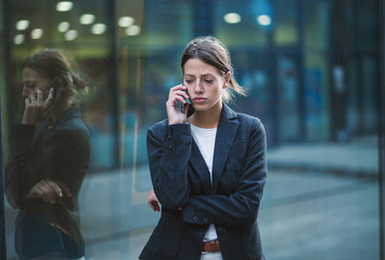 Unhappy business woman talking on the phone
