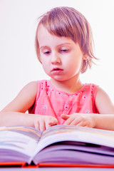 Portrait of cute little child girl is reading a book. Science, development, education concept