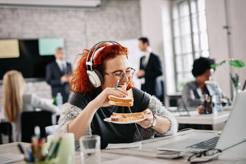 Young cheerful businesswoman enjoying on lunch break in the office.