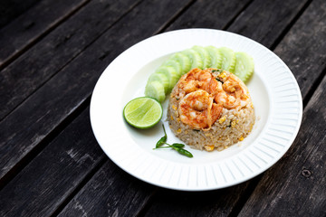 Shripms fried rice with fresh cucumber and green chili on wooden table background