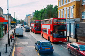 Red double decker bus on road in downtown street London - obrazy, fototapety, plakaty