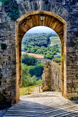 View of farmland through arch in Tuscany Italy