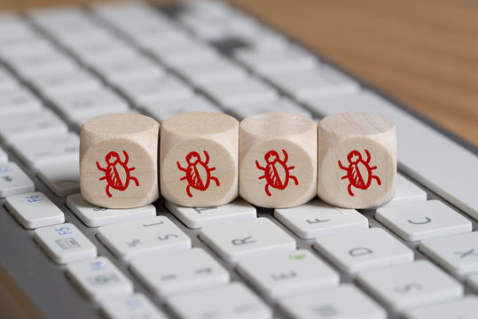 Würfel mit Käfersymbolen auf Computer Tastatur 