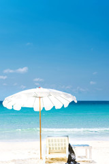 Summer vacation deckchairs and umbrella on tropical beach and ocean sea background. Travel and vacation background.
