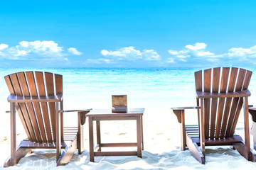 Summer vacation deckchairs on tropical beach and ocean sea background. Travel and vacation background.