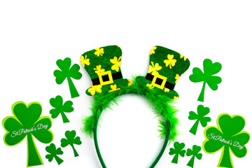 St Patricks day, festive leprechaun hat on headband and green Shamrocks on white background
