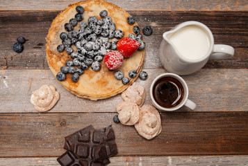 Healthy breakfast, coffee and homemade pancakes with fresh berries on wooden table
