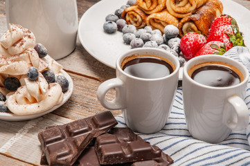 Healthy breakfast, coffee and homemade pancakes with fresh berries on wooden table