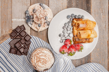 Healthy breakfast, coffee and homemade pancakes with fresh berries on wooden table