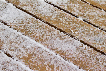 Frosty close up abstract background of a snow covered cedar deck floor