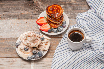 Healthy breakfast. Coffee and delicious pancakes, with fresh berries on wooden table