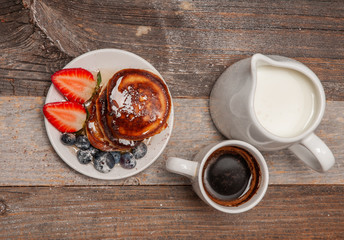 Healthy breakfast. Coffee and delicious pancakes, with fresh berries on wooden table
