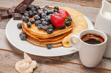 Healthy breakfast, coffee and homemade pancakes with fresh berries and banana
