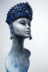 Head of woman mannequin in blue decorated kokoshnick, grey studio background