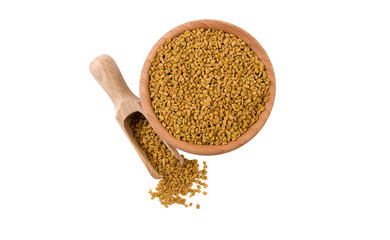 fenugreek seeds  in wooden bowl and scoop isolated on white background. top view. Spices and food ingredients.