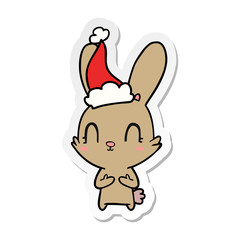Fototapeta na wymiar cute sticker cartoon of a rabbit wearing santa hat