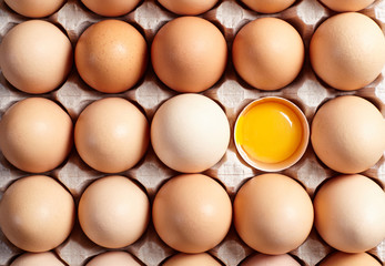  Broken egg among whole eggs. Top view.