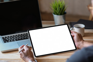 Side view of a man holding tablet in a conner office