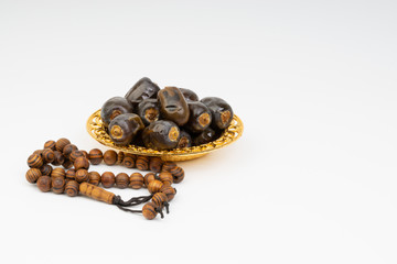 Dates and Rosary on white background with selective focus and crop fragment. Ramadan, Religion and Copy space concept. Black and White