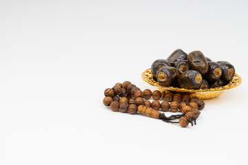 Dates and Rosary on white background with selective focus and crop fragment. Ramadan, Religion and Copy space concept. Black and White