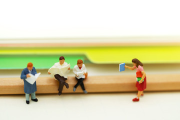 Fototapeta premium Miniature people: Business team reading book, education or business concept.