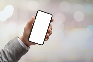 Man hands holding blank screen smartphone with blurred background.  Blank screen mobile phone for graphic display montage..