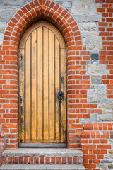 Stone and brick exterior detail of Christ Church Cathedral, brick and concrete stairs leading up to a wooden side door
