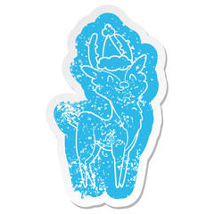cartoon distressed sticker of a happy stag wearing santa hat