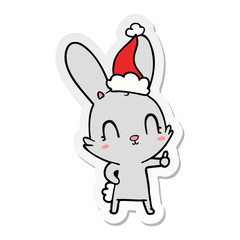 Fototapeta na wymiar cute sticker cartoon of a rabbit wearing santa hat