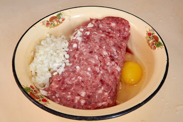 fresh beef and pork minced meat sprinkled with white onions and chicken egg for making cutlets and...