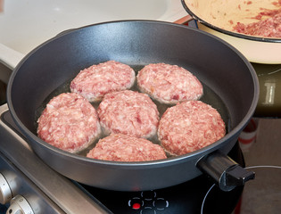 at home in the kitchen, roasts in a hot frying pan on an electric stove a lot of minced meat of pork and beef. cooking at home. tasty healthy food