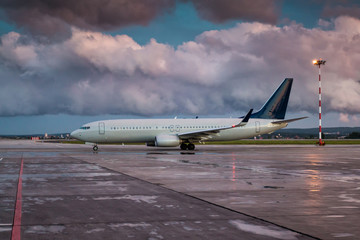 Taxiing a passenger aircraft on the airport apron on an overcast evening after rain