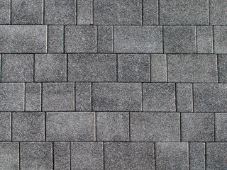 Fototapeta premium Background from a gray road rectangular tile with a small multi-colored crumb