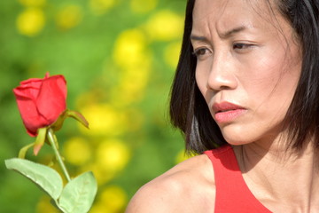 Naklejka premium Unemotional Asian Person With A Rose