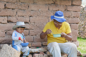 Native american man eating with his little son outside.