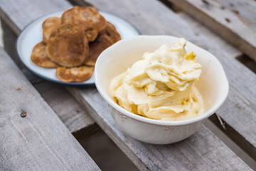 Homemade banana vanilla ice cream with pancakes on wooden table for breakfast.
