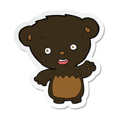 sticker of a cartoon black bearcub waving