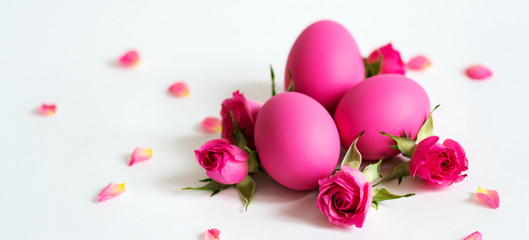 Decorative Easter eggs and pink roses Pink Easter eggs on light background. Holiday card.