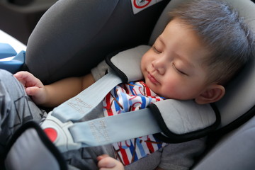 cute baby boy sleeping in car seat safety belt lock protection drive road trip travel
