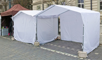 White canvas no name tents  for small markets  is installed on the street