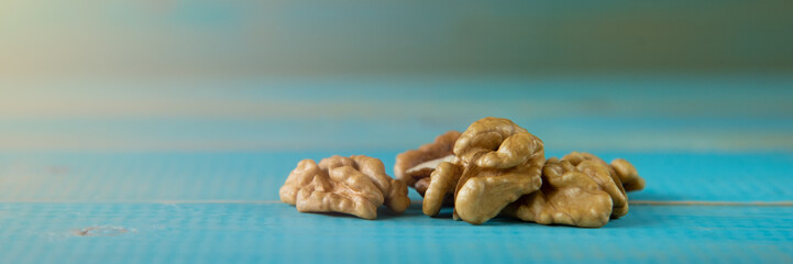 Walnut kernels on a blue wooden background.