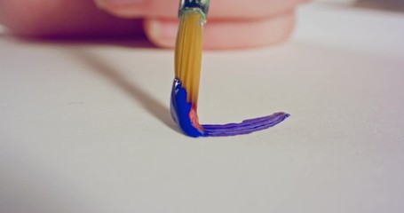 Macro shot of brush painting on paper with acrylic colors