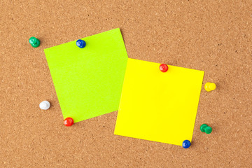 Cork board with several colorful blank notes with pins