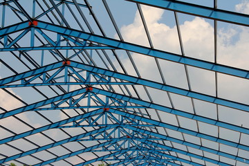 Structure of steel roof frame for building construction on sky background