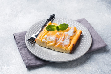 Cottage cheese casserole on a plate with powdered sugar and mint leaves. Selective focus