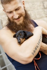 Young man walking dog on street