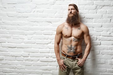 Young muscular bearded white man half naked
