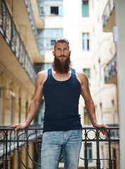 Muscular young bearded man in staircase
