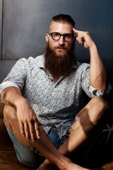 Portrait of young smart bearded man in glasses